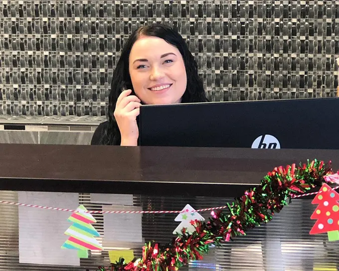A broker welcoming a client at the front desk
